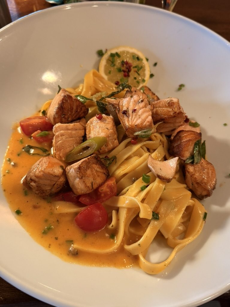 Tagliatelle mit gebratenem Lachs, Kirschtomaten und Frühlingszwiebeln in cremiger Sauce