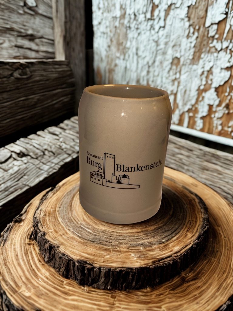 Steinzeug-Tonkrug mit dem Logo der Burg Blankenstein auf einer Baumscheibe